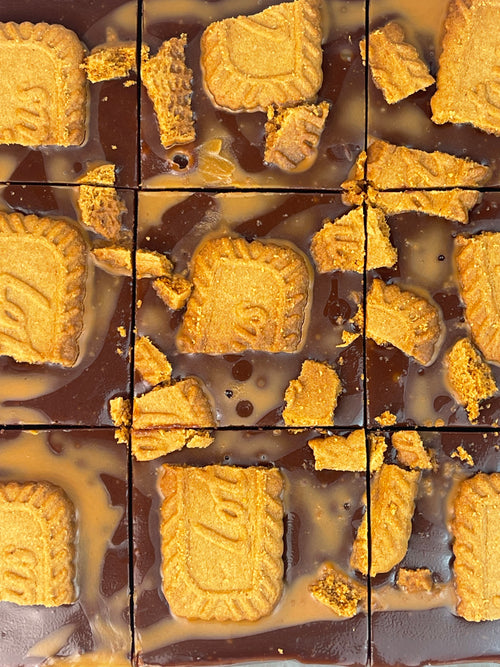 Chocolate-covered cookies with visible brand logo on a grid background