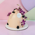 Decorative cake with purple flowers and blackberries on a pastel background