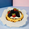 Small dessert tart with berries on a light blue background