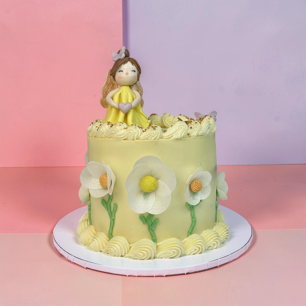 Decorative cake with a figurine and floral designs on a pink and purple gradient background