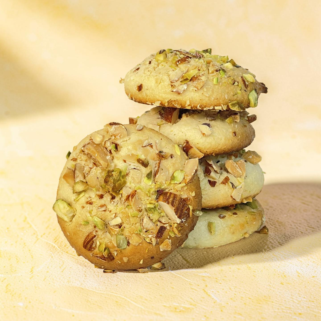 Stack of cookies with pistachios on a wooden surface