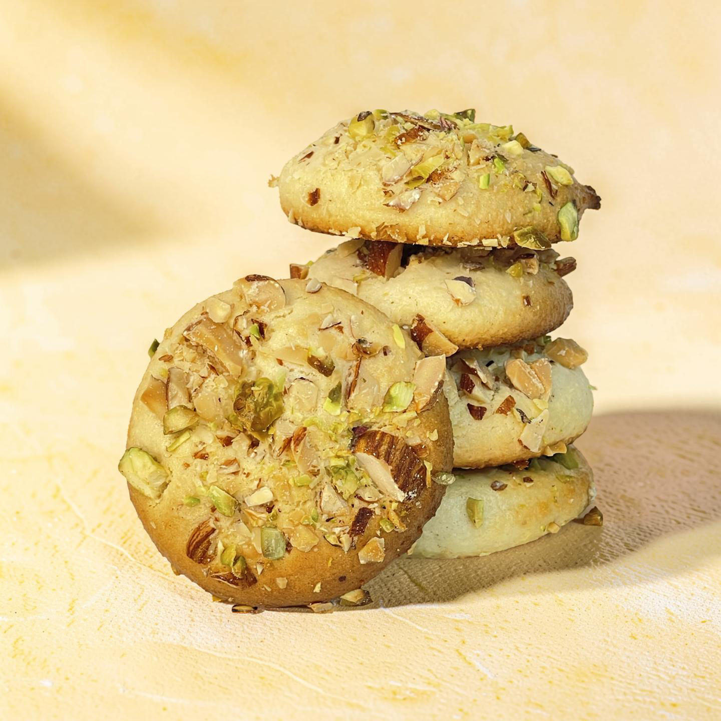 Stack of cookies with pistachios on a wooden surface