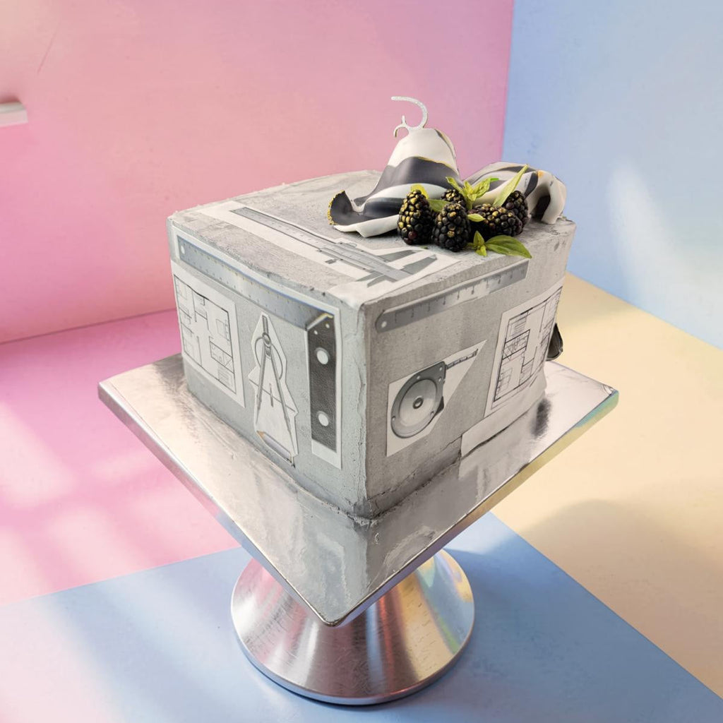 Square cake with a detailed design on a stand against a pastel background
